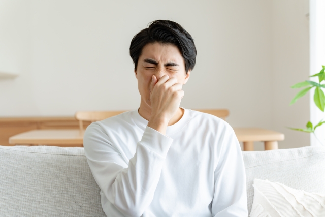 鼻を抑える男性
