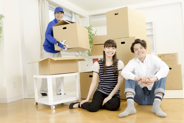 引っ越しする男女と引っ越し作業員